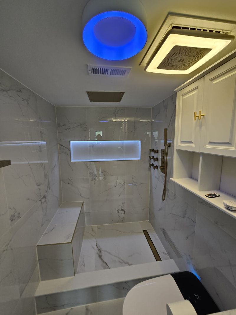 Marble shower with a glowing ring light and a lit shower niche