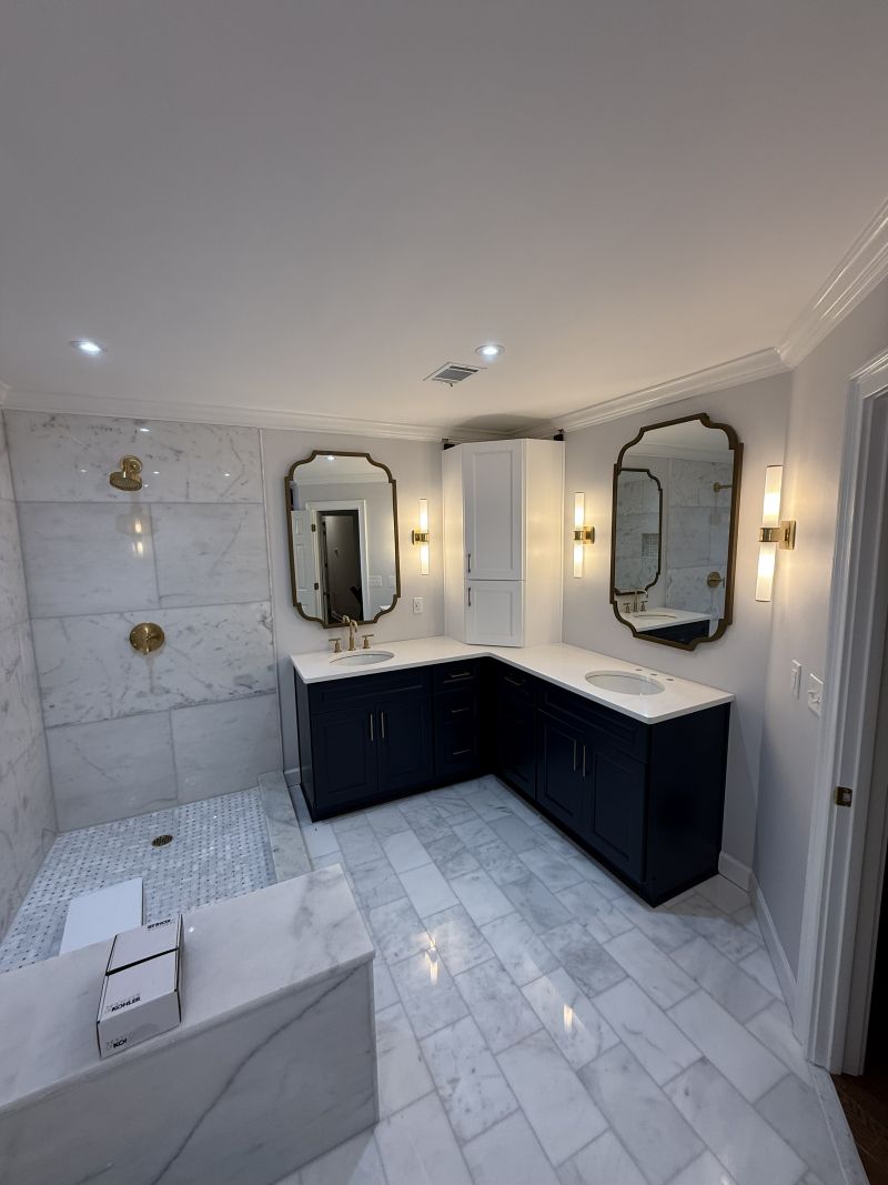 Gold sconces beside two mirrors over a navy double vanity